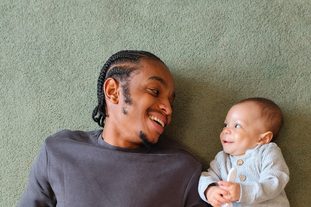 Un homme et un nourrisson se regardent en souriant