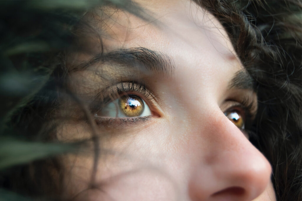 Le regard d'une jeune femme orienté vers le ciel